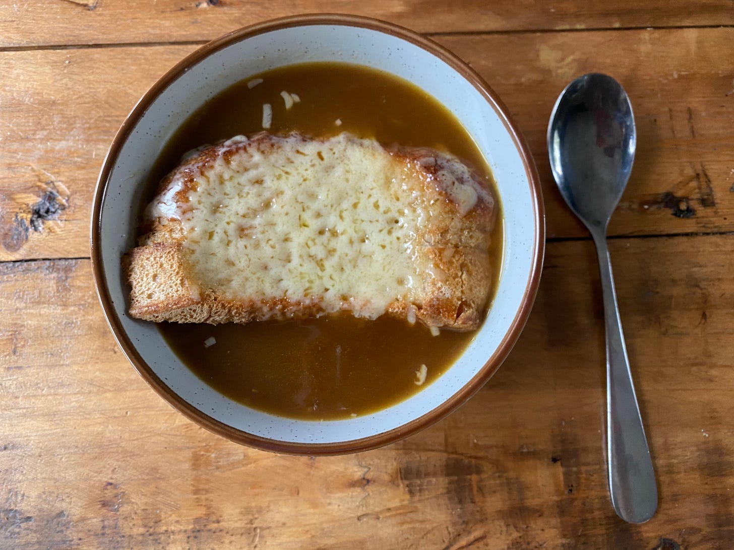 Bowl of onion soup with a cheesy crouton