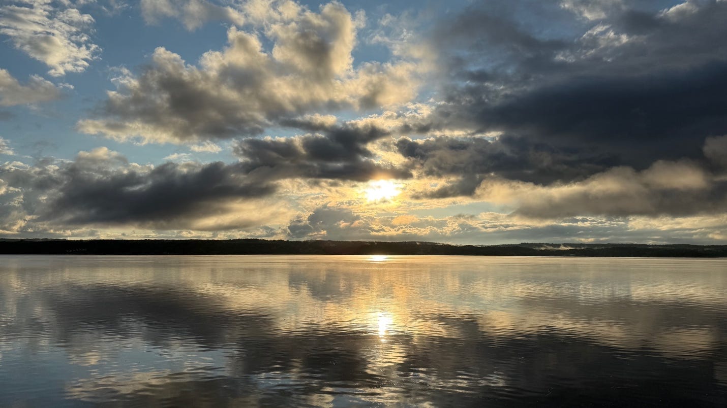 A body of water with clouds and a sun

AI-generated content may be incorrect.