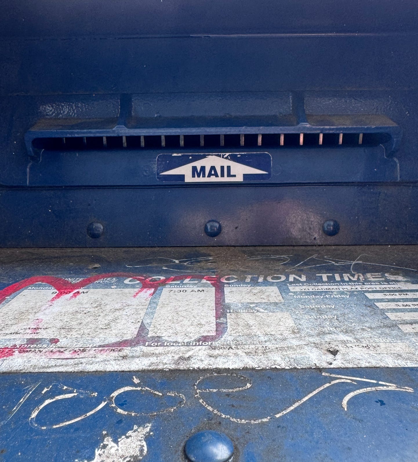 A close up of the mail slot of a United States Postal Service blue mailbox.