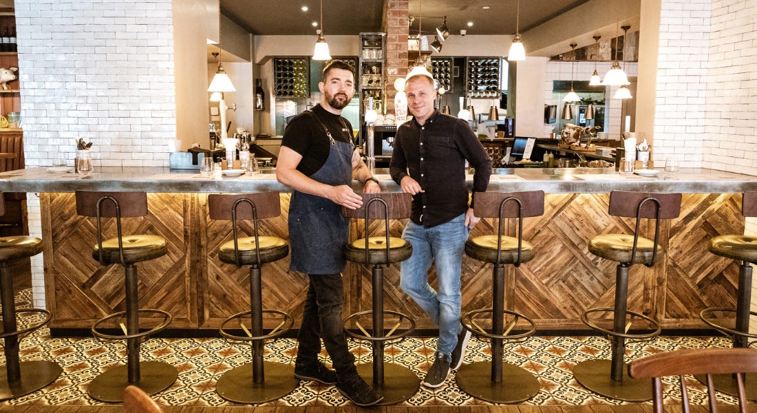 Two men stood together at a bar in Bar Iberico's restaurant Two men stood together at a bar in Bar Iberico's restaurant