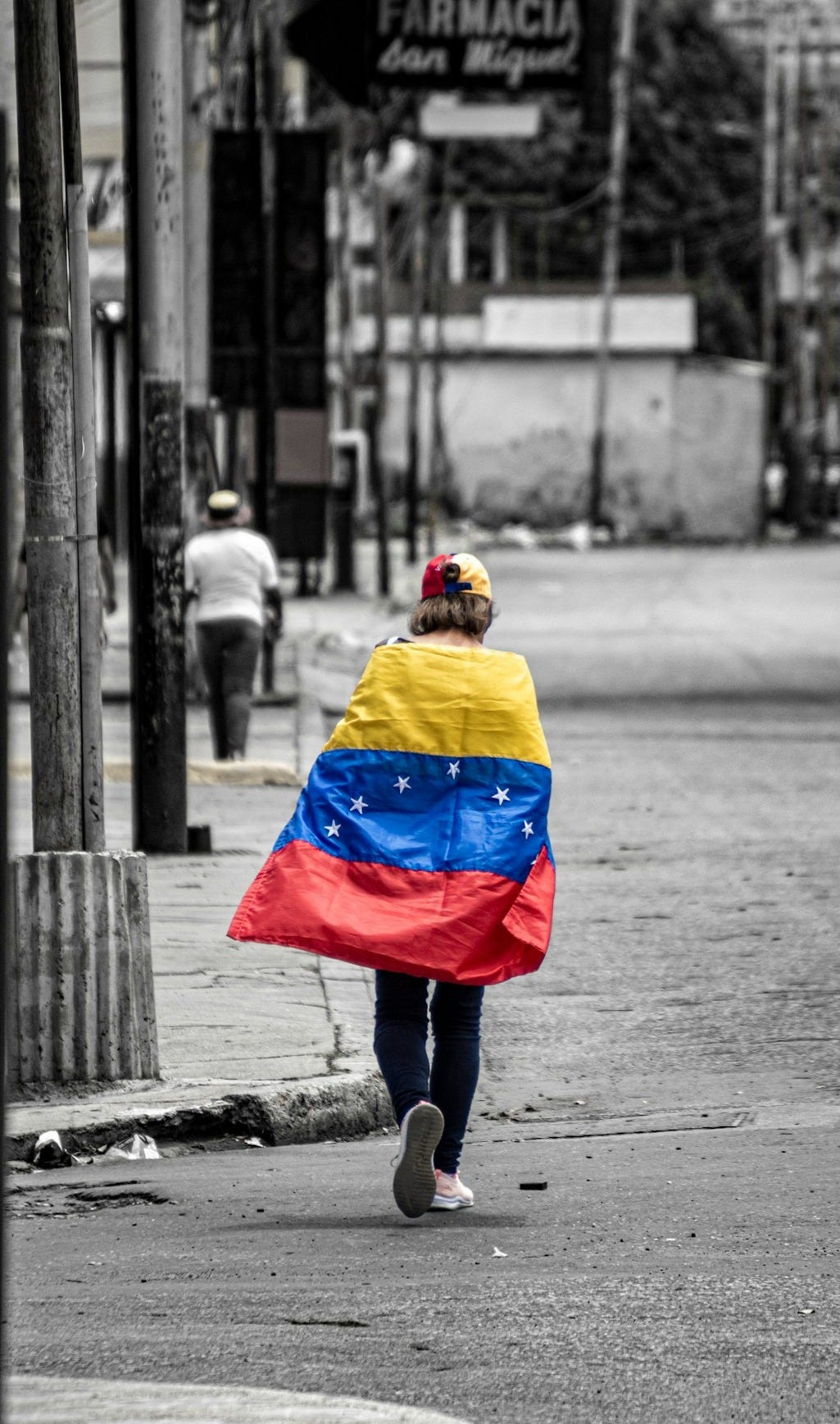 A person walking down a street holding a flag