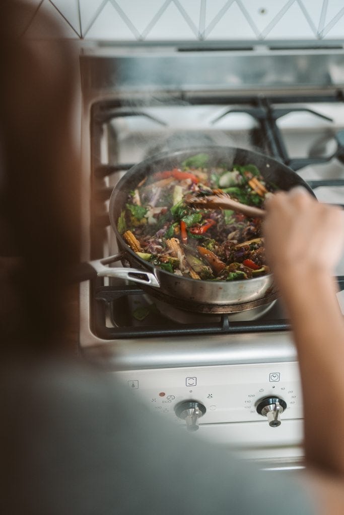 Are you an active or passive patient? Woman cooking meal on stovetop.