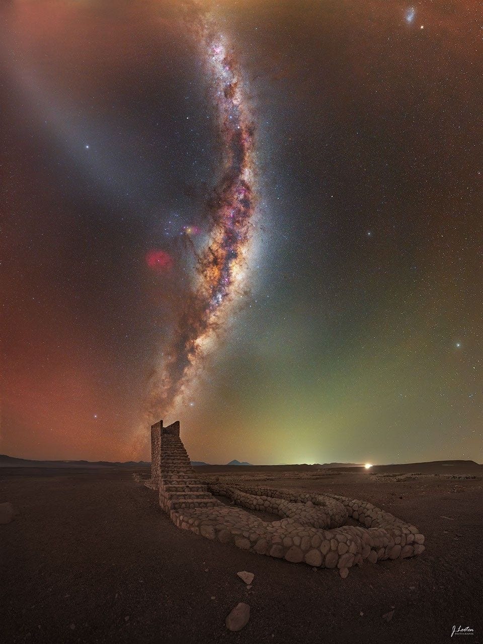 The Milky Way galaxy rises from the horizon and curves upward in the sky. In the foreground, a rock pathway is seen that culminates in a staircase that ends abruptly. The Milky Way band appears to be a continuation of the staircase. Please see the explanation for more detailed information. The Milky Way galaxy rises from the horizon and curves upward in the sky. In the foreground, a rock pathway is seen that culminates in a staircase that ends abruptly. The Milky Way band appears to be a continuation of the staircase. Please see the explanation for more detailed information.