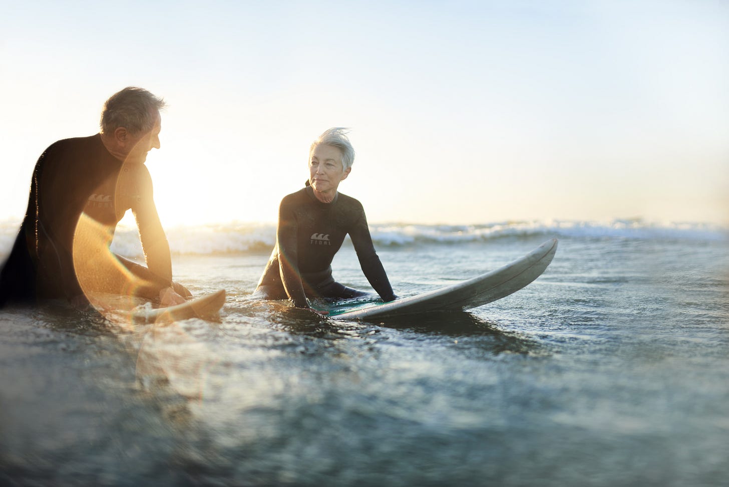 Older couple surfing at dusk. Older couple surfing at dusk.