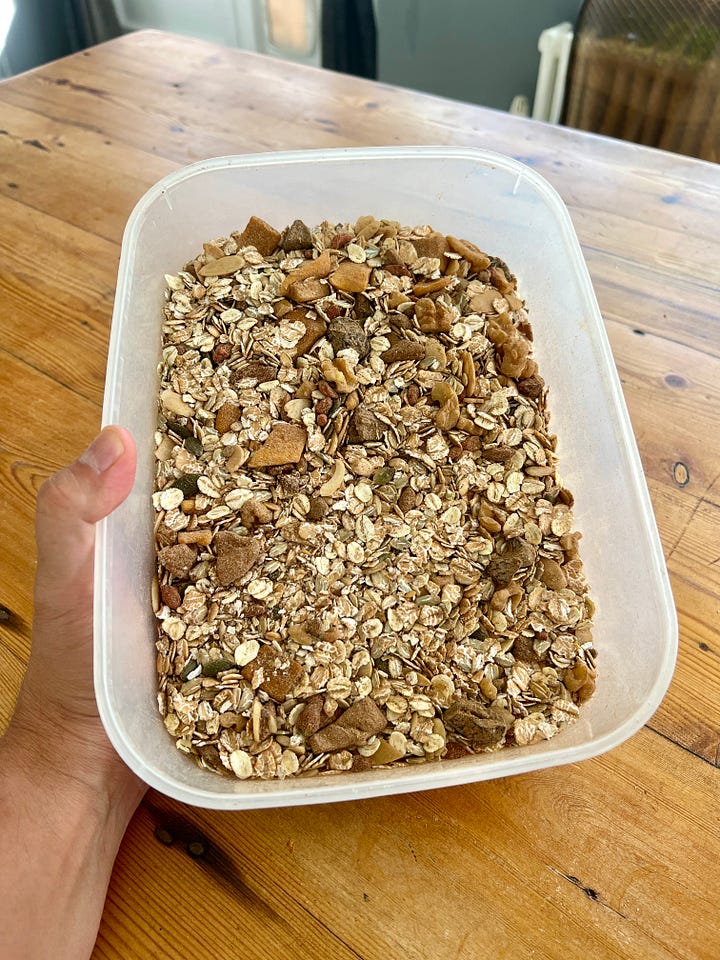 Various cereals, whole grains, herbs and spices on a worktop and in a container.