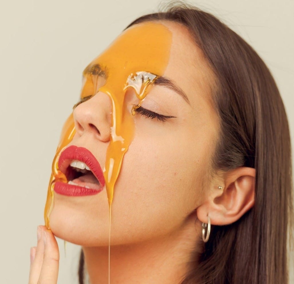 a woman with a yellow substance on her face
