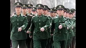 A group of soldiers in green uniforms march in step.