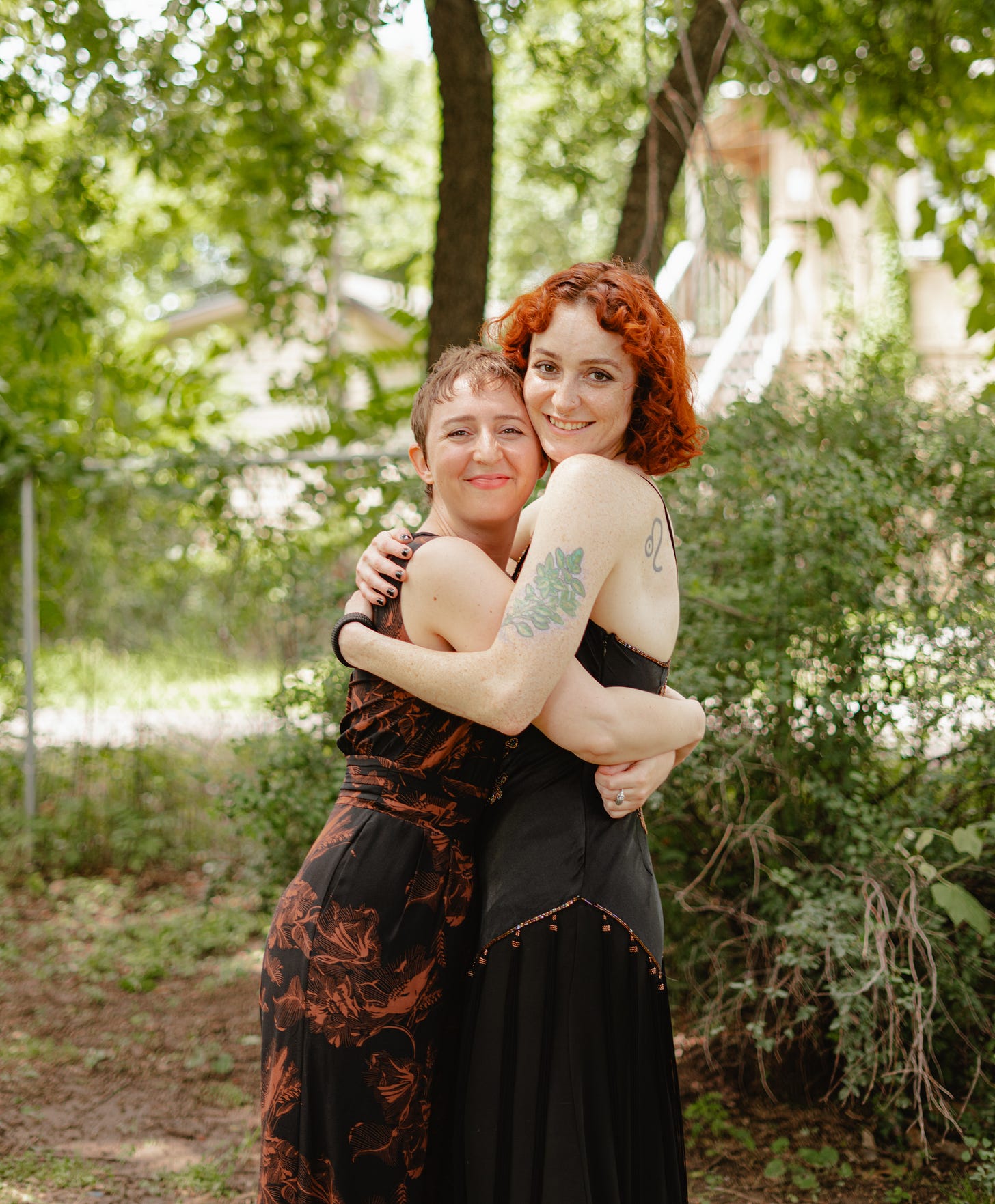 Maeg and Jo hugging with greenery in the background