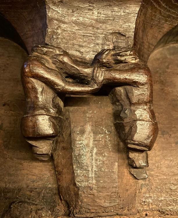 A wood carving of two people

Description automatically generated