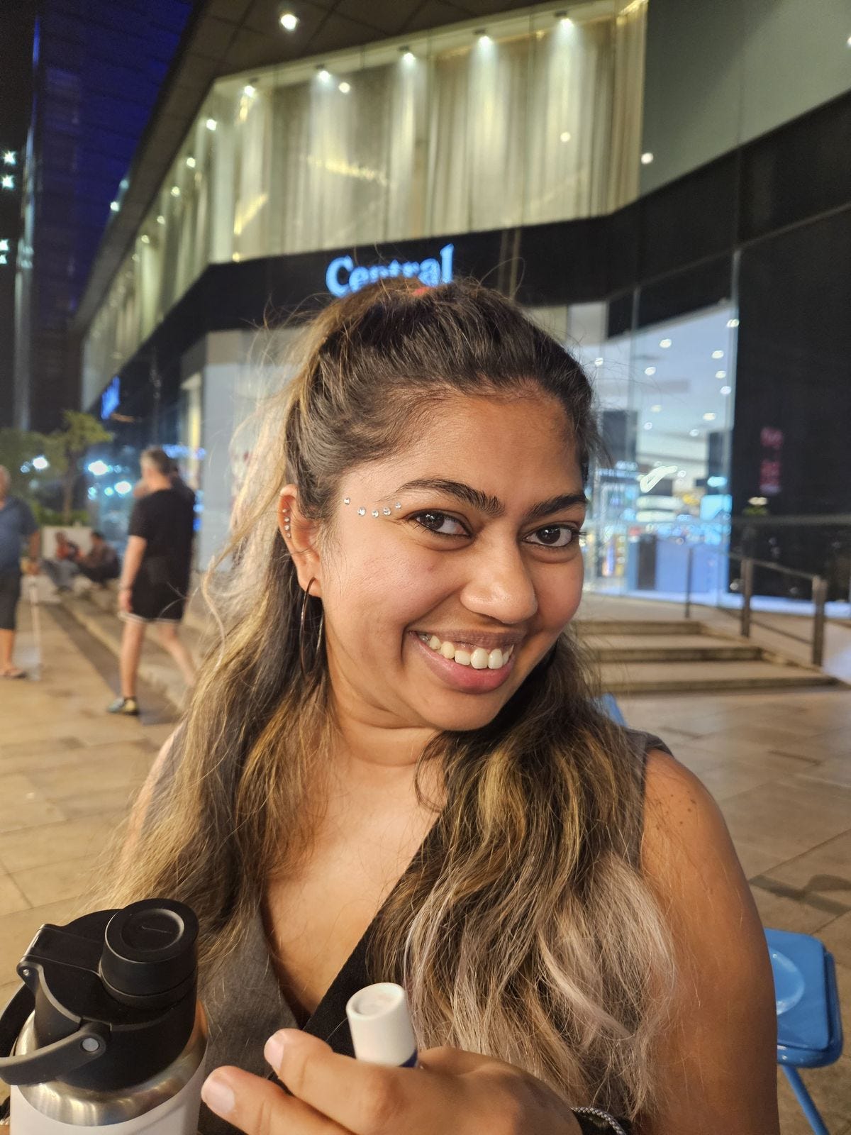 A random picture of Seni seated outdoors with rhinestones on her face lol
