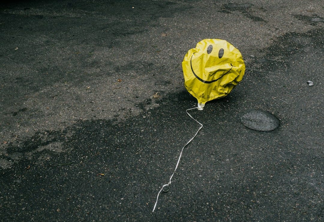 smiling emoji balloon beside black car during daytime smiling emoji balloon beside black car during daytime