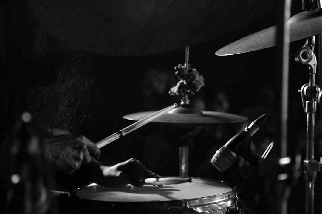 a person playing drums in a dark room a person playing drums in a dark room