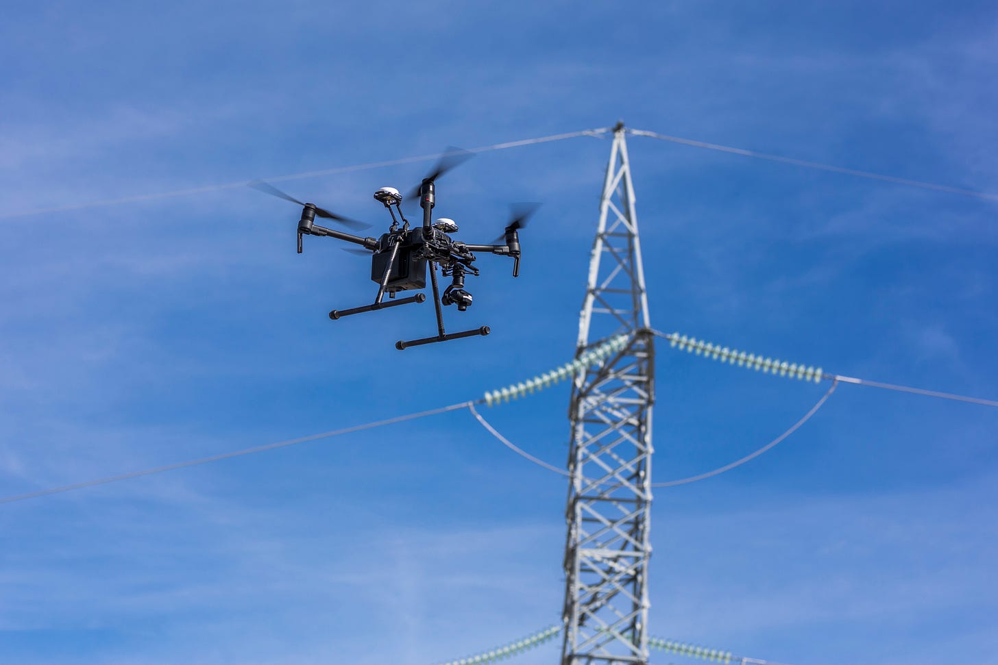 Picture of a drone flying in the sky inspecting powerlines Picture of a drone flying in the sky inspecting powerlines