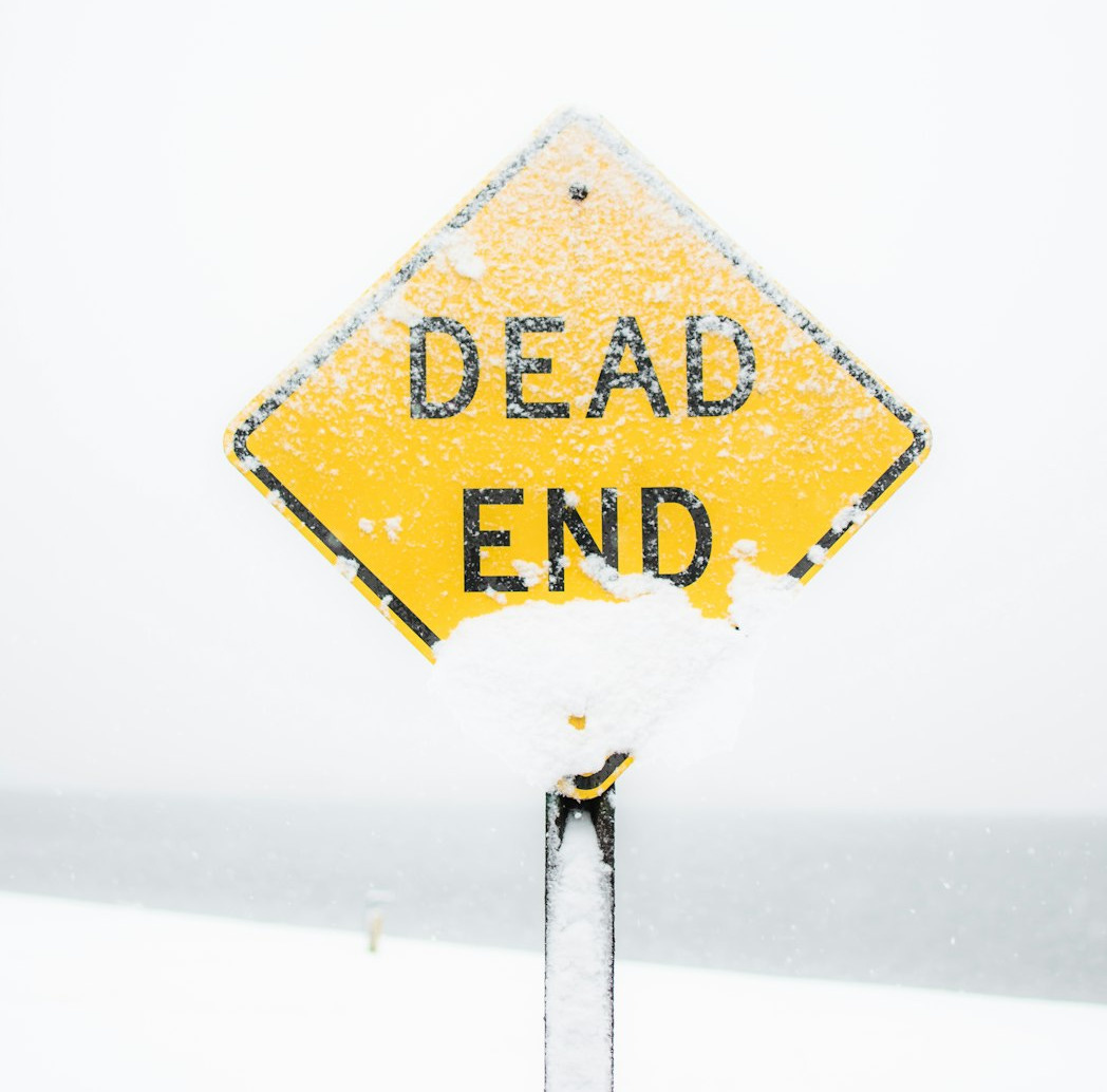 focus photography of dead end road sign covered with snow
