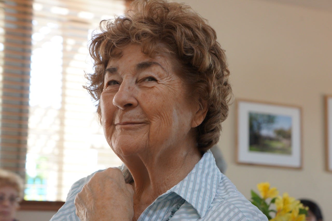 an older woman with a smile on her face and a twinkle in her eyes