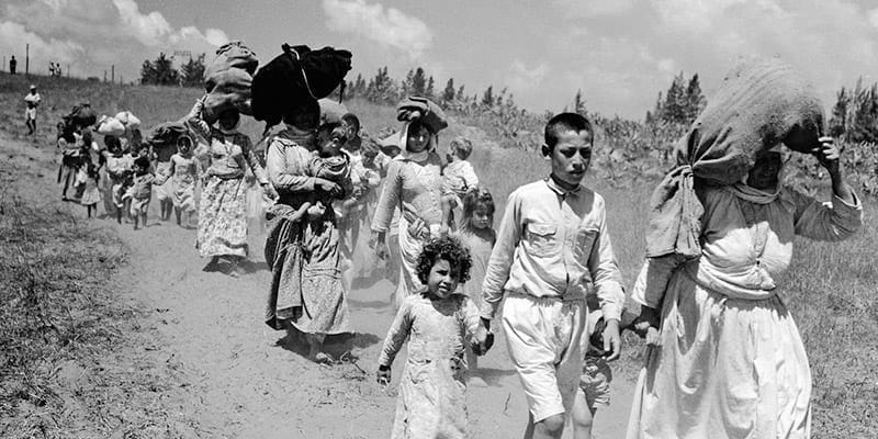 Palestinian refugees walking with belongings during the 1948 Nakba