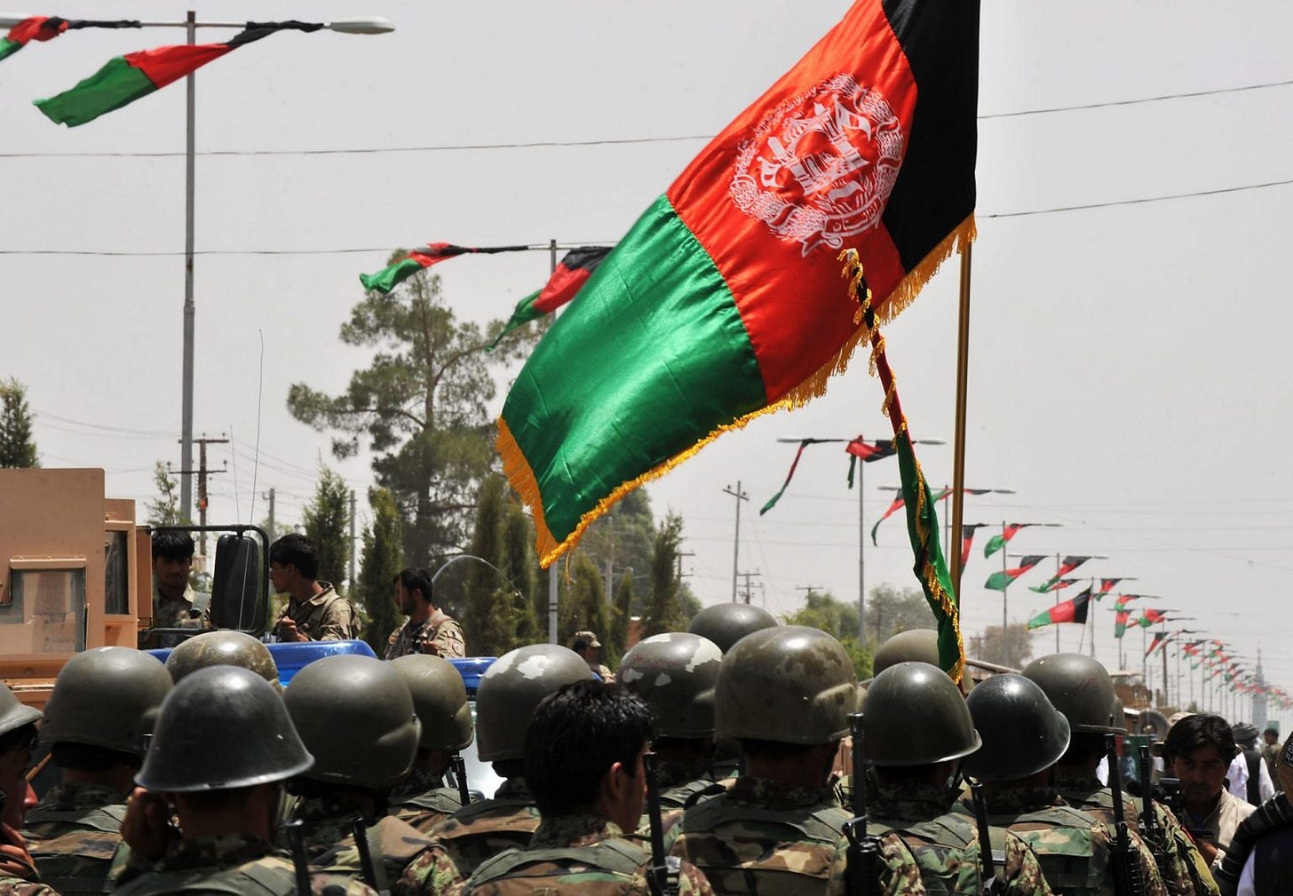 A group of people in military uniforms holding a flag

Description automatically generated with low confidence