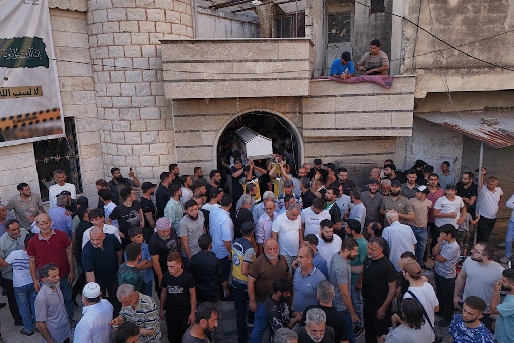 Mourners carry the coffin of Mohammad Ghamira, a former White Helmets volunteer who died shortly after his release from jail, for burial in the village of al-Haffa, in Latakia province, Syria, Aug. 17, 2026 (AP) Mourners carry the coffin of Mohammad Ghamira, a former White Helmets volunteer who died shortly after his release from jail, for burial in the village of al-Haffa, in Latakia province, Syria, Aug. 17, 2026 (AP)
