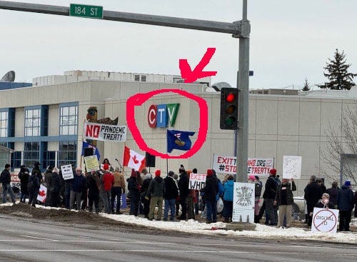 A group of people protesting in front of a building

Description automatically generated