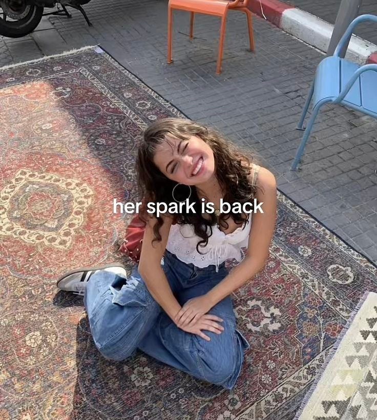 This may contain: a woman sitting on the ground in front of a rug This may contain: a woman sitting on the ground in front of a rug