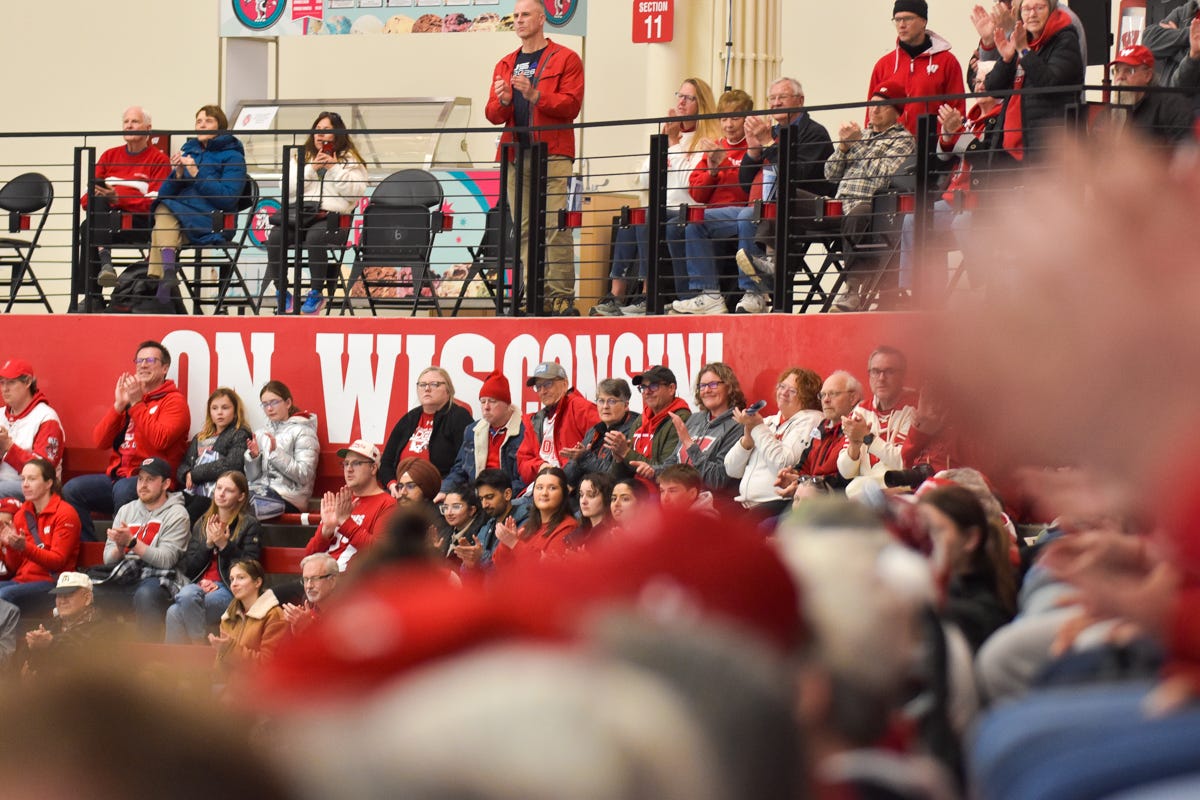 Fans in Wisconsin Badgers geat seated up to the top row of a section at LaBahn Arena