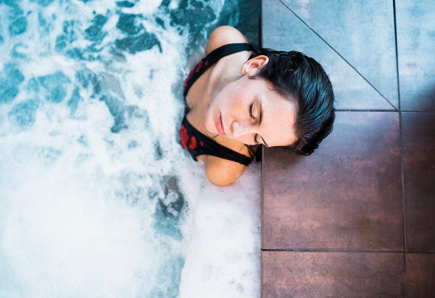 dark-haired woman in hot tub with eyes closed