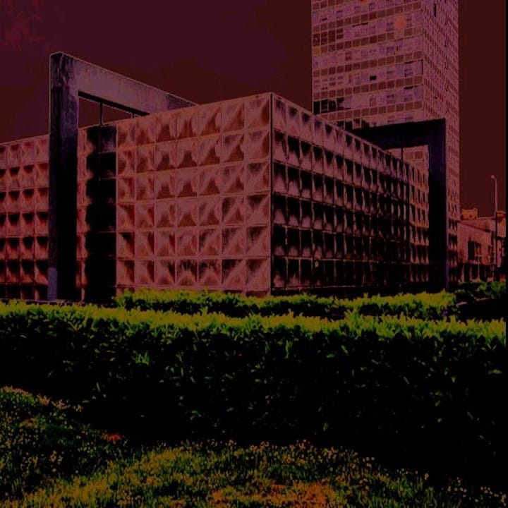 A three-quarter view of the Michael Faraday memorial in Elephant and Castle, a stainless steel single storey box building with neatly trimmed waist high hedgerows in the foreground. The photo is manipulated to be cherry-red, green, and black.