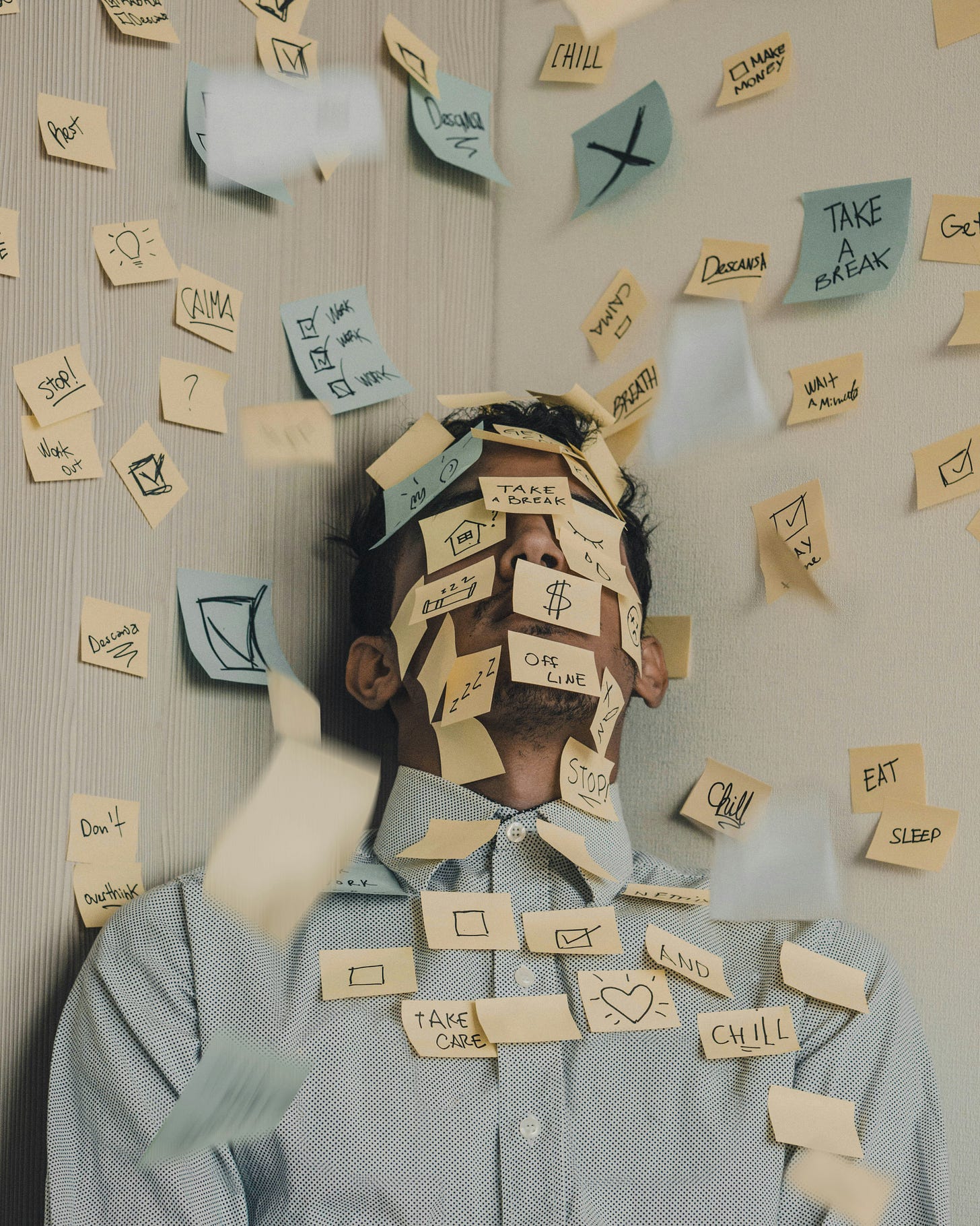 Person in business casual shirt covered in sticky notes with workplace demands and wellness buzzwords like 'Take a Break,' 'Chill,' 'Breathe,' 'Offline,' 'Create,' and 'Stop,' illustrating burnout and the overwhelming pressure of modern work culture" Person in business casual shirt covered in sticky notes with workplace demands and wellness buzzwords like 'Take a Break,' 'Chill,' 'Breathe,' 'Offline,' 'Create,' and 'Stop,' illustrating burnout and the overwhelming pressure of modern work culture"