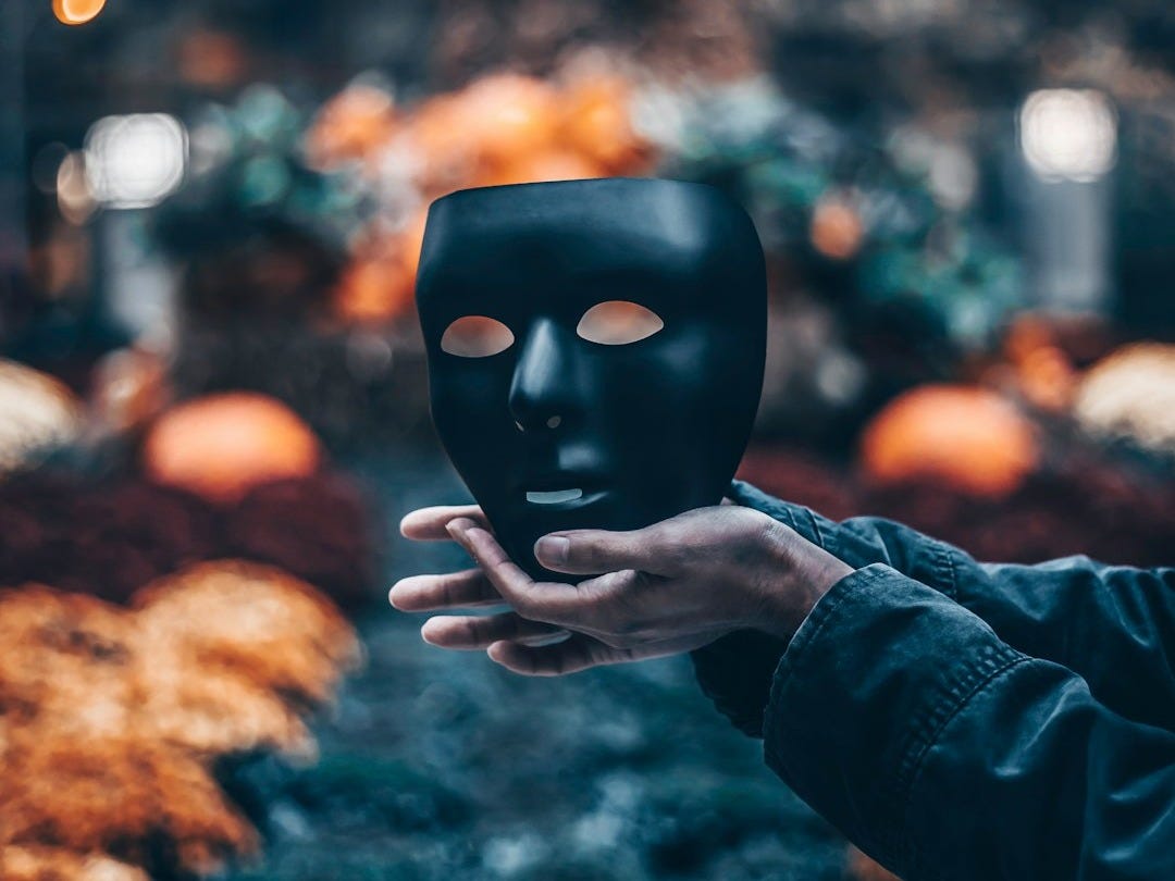 person holding black mask person holding black mask