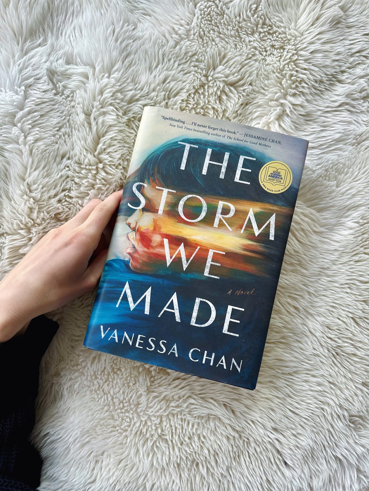 A copy of The Storm We Made on a white fluffy blanket