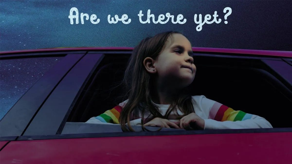 Young girl sticking her head out of a car window with text "Are we there yet?"