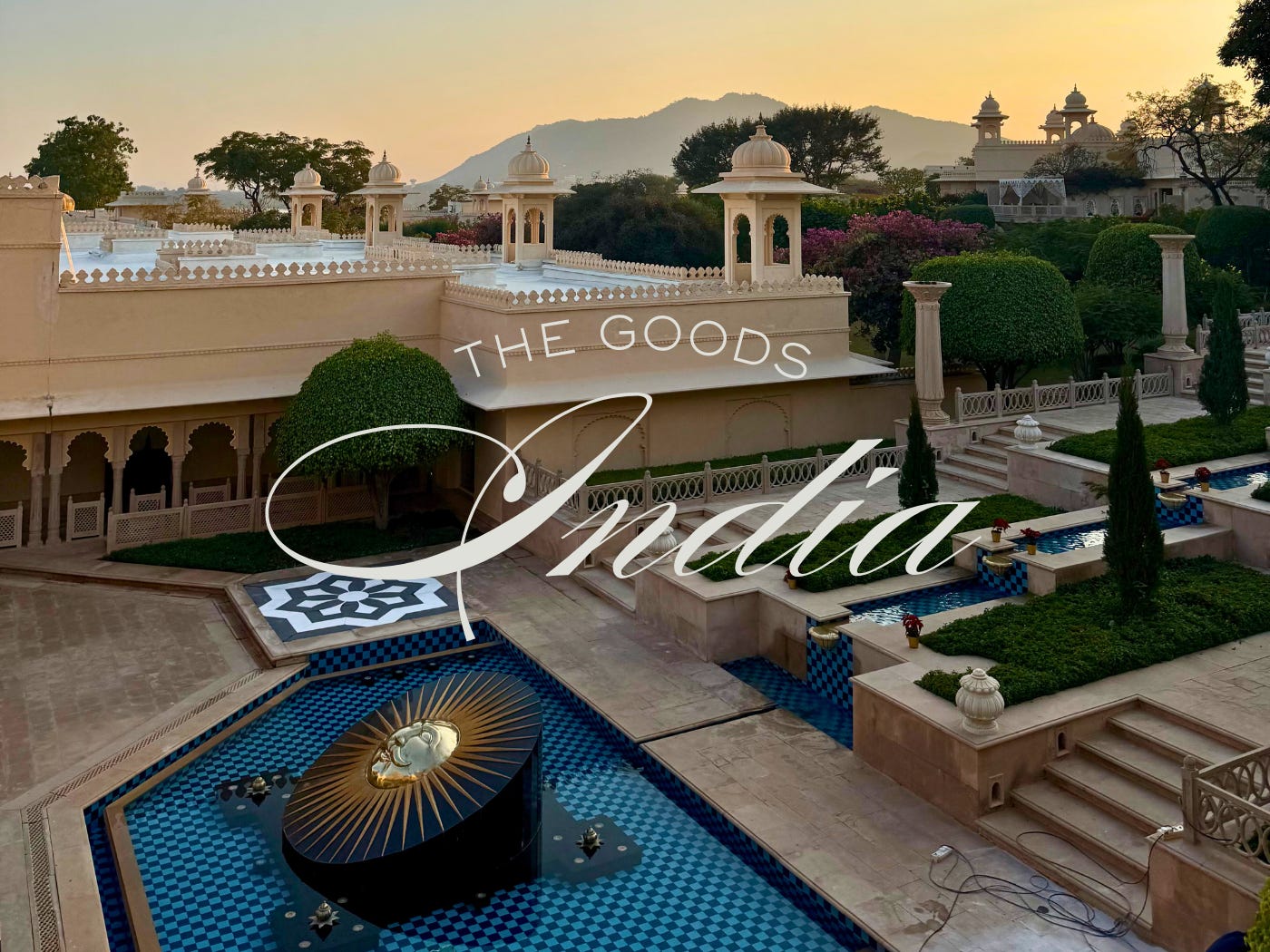 Palace courtyard at sunset with a blue tiled pool and domed pavilions, with “The Goods: India” text overlaid. Palace courtyard at sunset with a blue tiled pool and domed pavilions, with “The Goods: India” text overlaid.