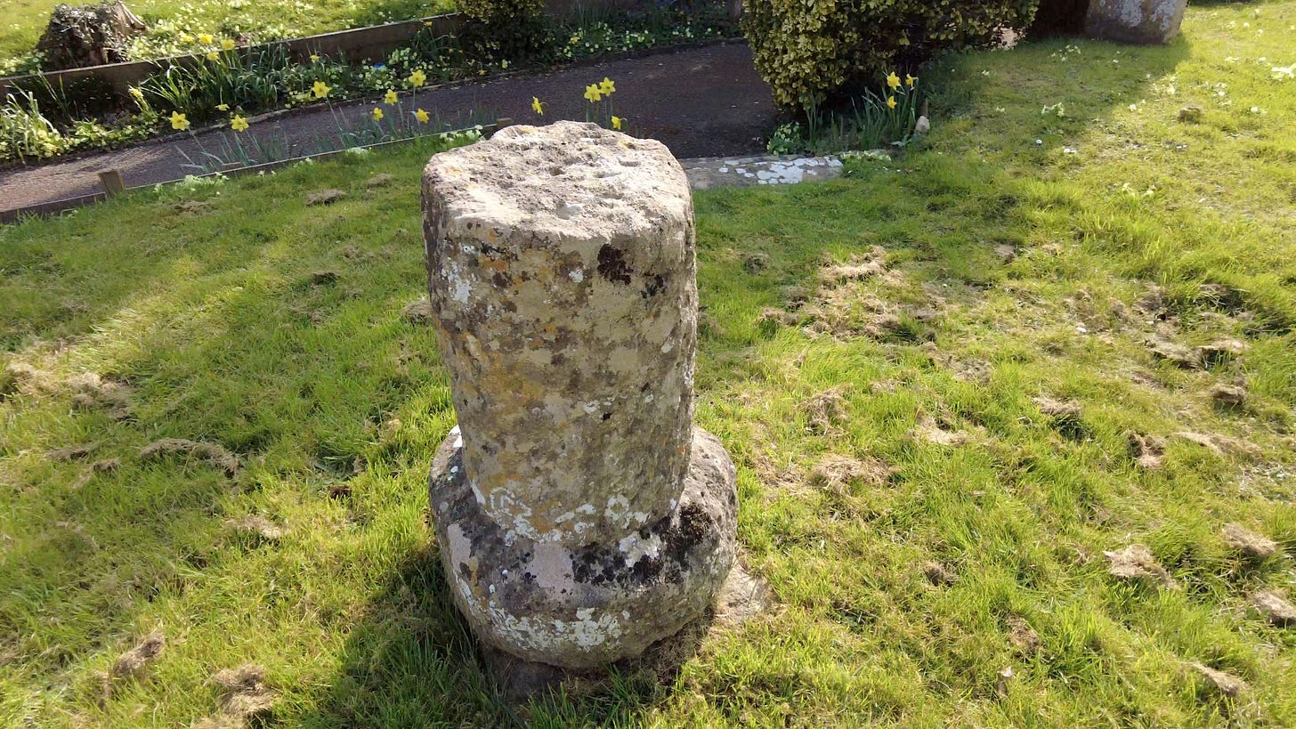 The stone base of a 12th century relic in the churchyard at St Mary's Broughton Gifford, Melksham, Wiltshire 