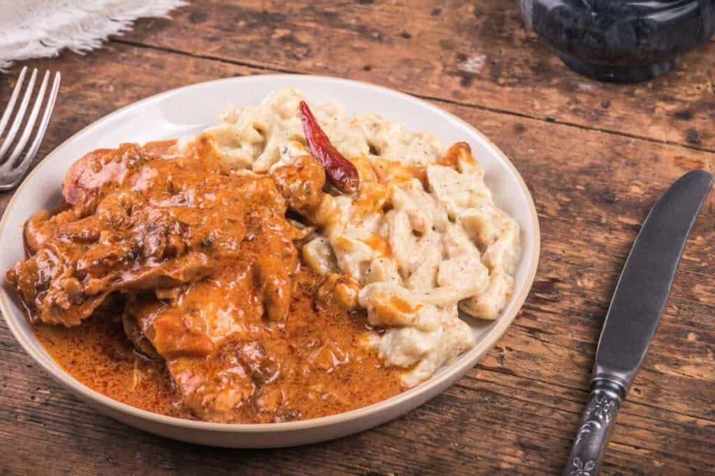 Finishe Chicken Paprikash on a white plate with spaetzal