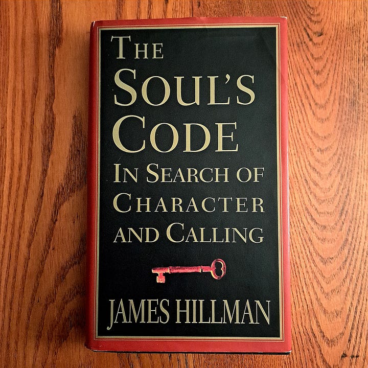 hand in a garden holding The Way of the Fearless Writer, and The Soul's Code book on a wooden tablebook covers