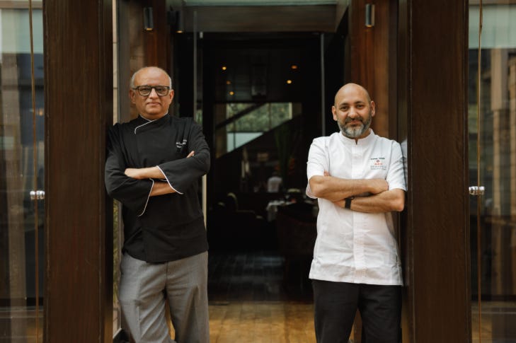 Chefs Sameer Taneja and Shantanu Mehrotra posing in front of a restaurant door Chefs Sameer Taneja and Shantanu Mehrotra posing in front of a restaurant door