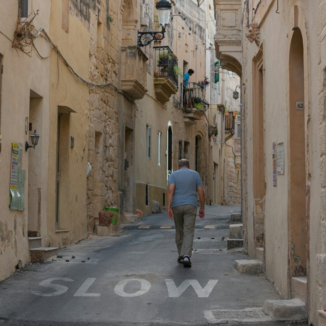 A man walking down a narrow alley way A man walking down a narrow alley way