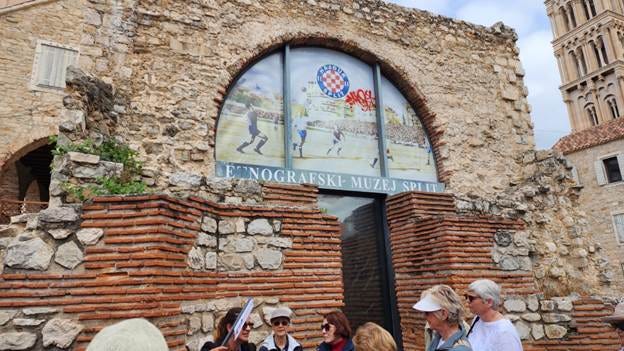 A group of people standing in front of a stone building

AI-generated content may be incorrect.