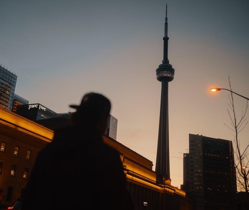 A man walking down a street next to tall buildings