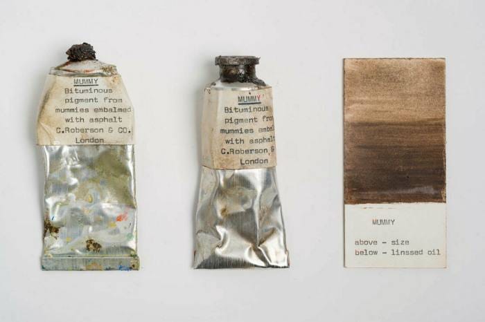 Two tubes of paint next to a paint chip showing two brown colours Two tubes of paint next to a paint chip showing two brown colours
