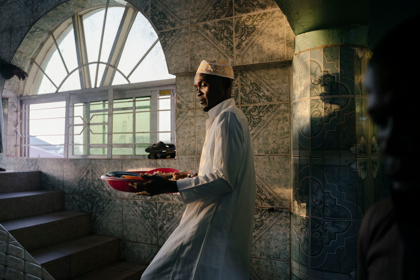 A volunteer distributes food for Iftar on the fourth day of the Holy month of Ramadan in Freetown, Sierra Leone on March 26, 2023. (Photo by Carmen Abd Ali/AFP via Getty Images)