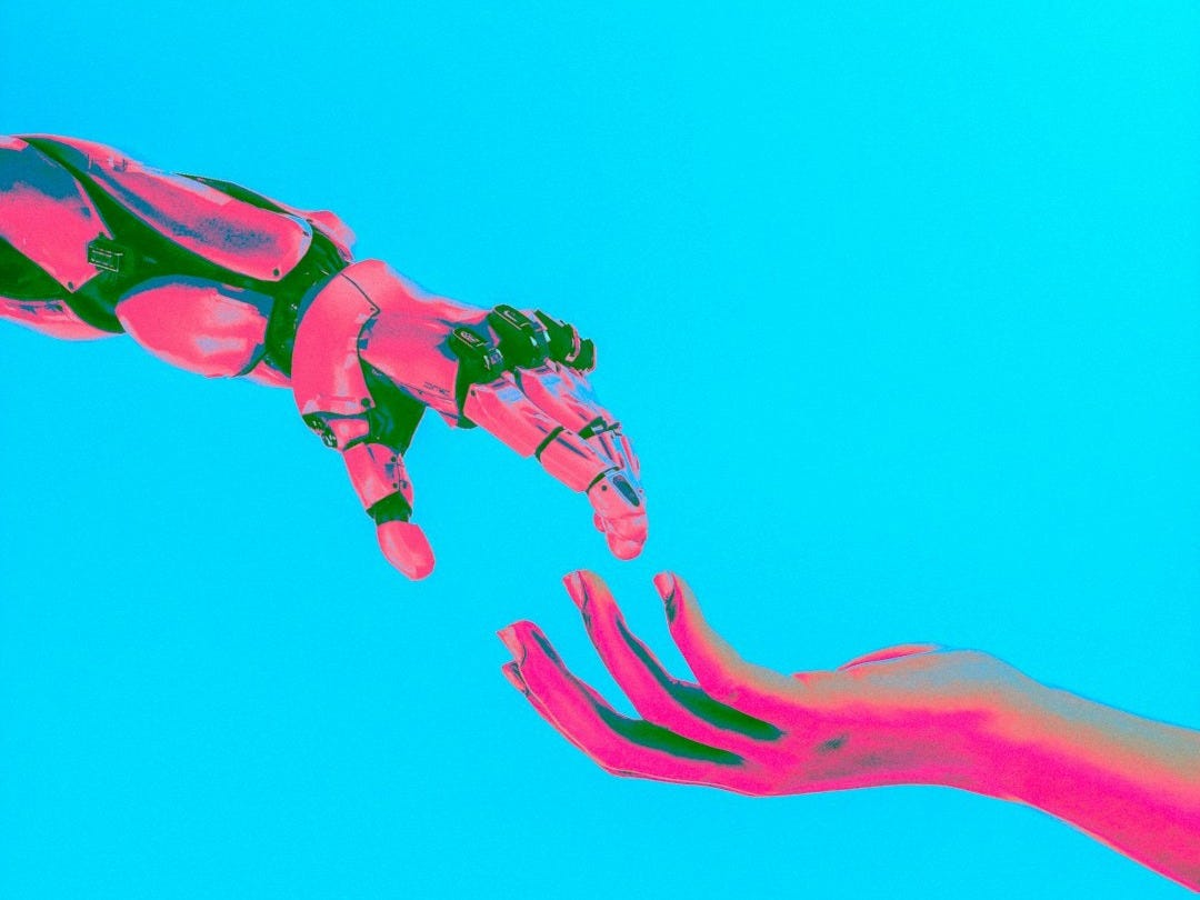 robot and human hands reaching toward each other robot and human hands reaching toward each other
