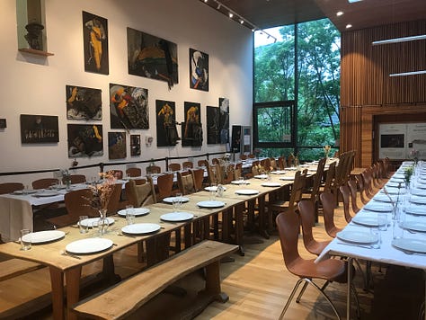 A poster for Falastin Film Festival saying 'sold out'; The room set for the Palestinian meal; Palestinian olives and chillies in small white bowls with cocktail sticks.
