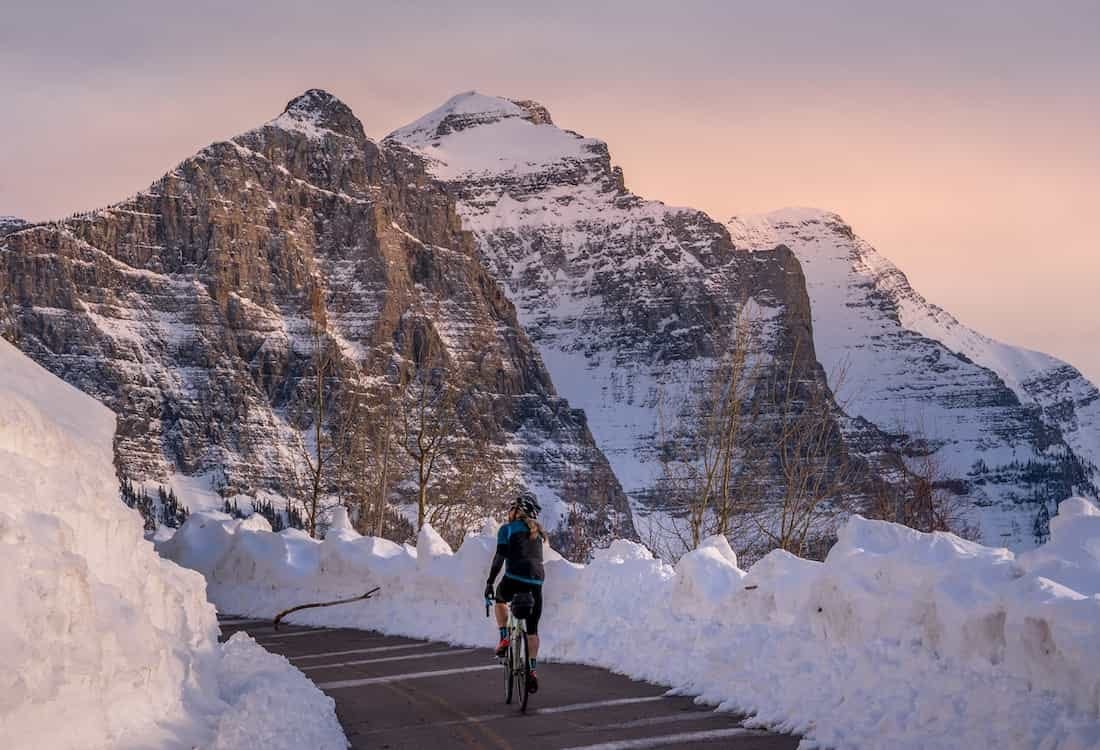 woman rides a bike on the going to the sun road in glacier national park woman rides a bike on the going to the sun road in glacier national park