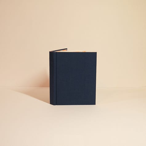 three different hand bound hard cover books.