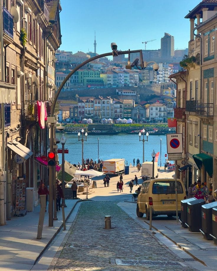 This may contain: a city street with cars and people walking on it
