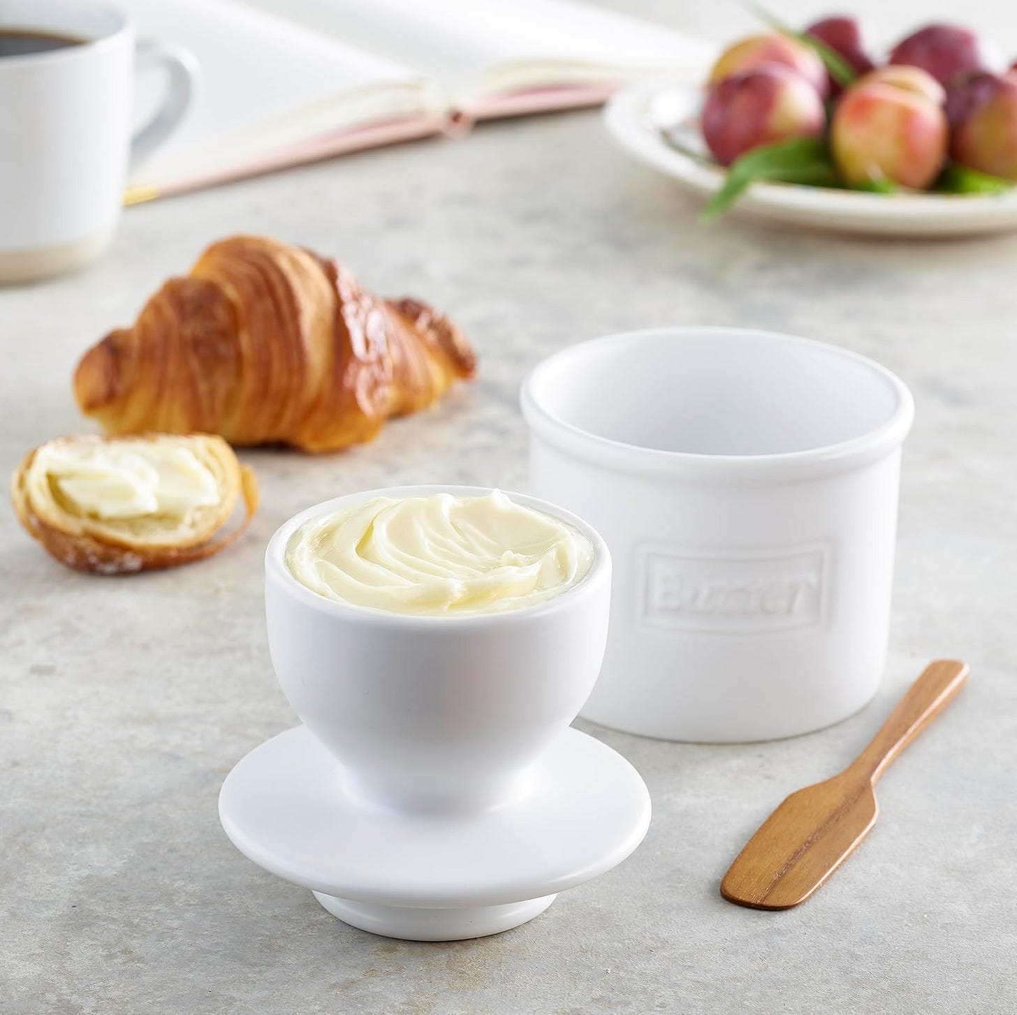 White butter bell, countertop ceramic butter keeper with a croissant in the background