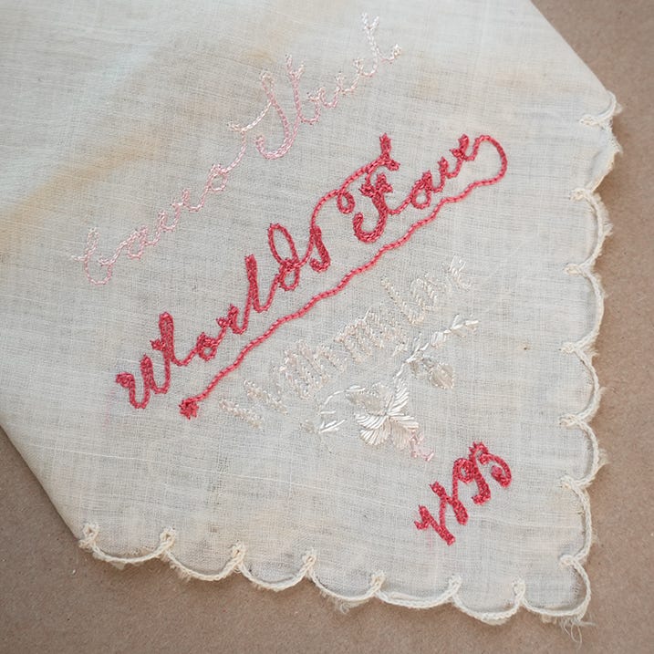 World's Fair chainstitch embroidery in pink thread on a white handkerchief 