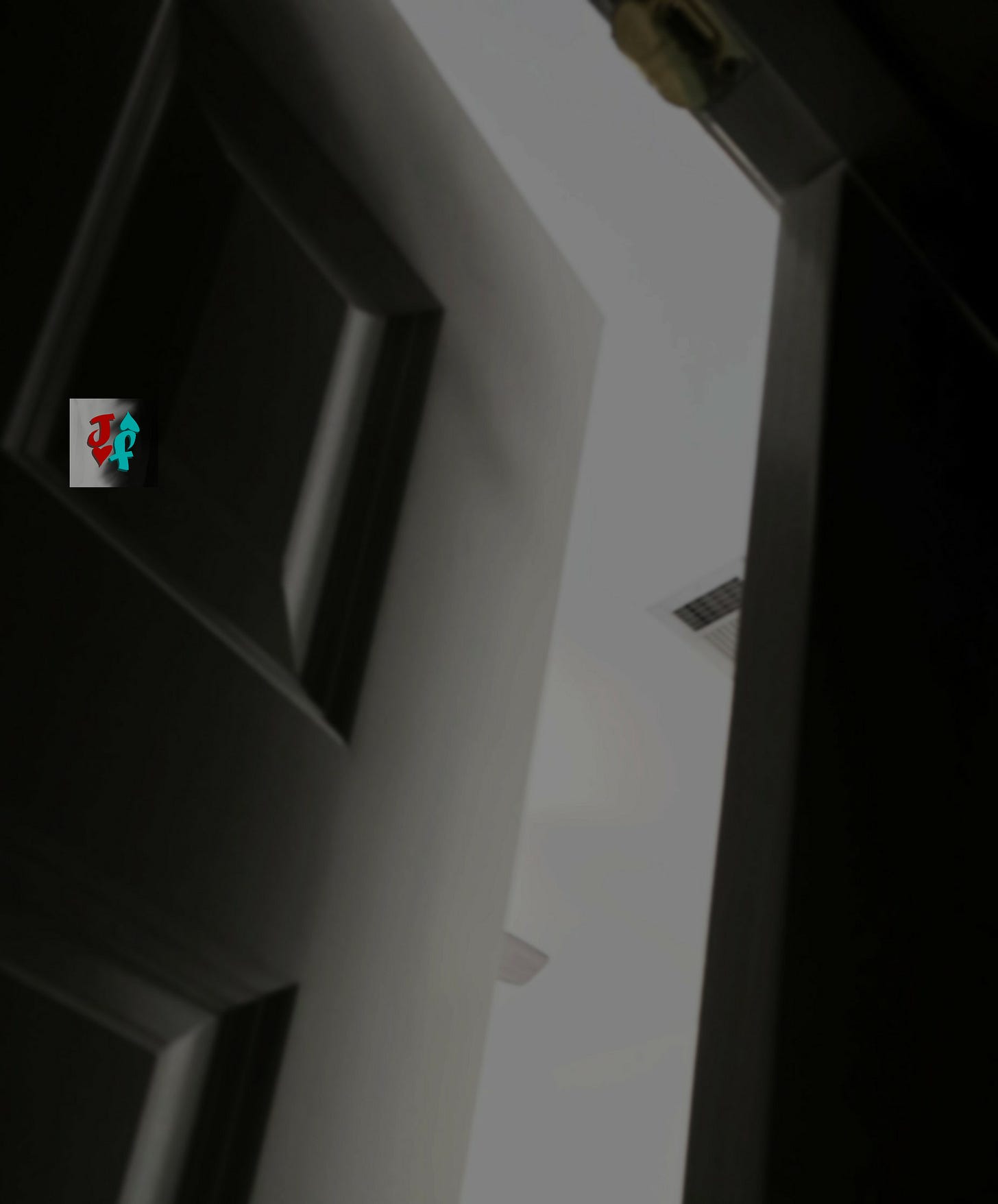A photo from inside a dark closet, looking into a bedroom at a ceiling fan and vent during the day.