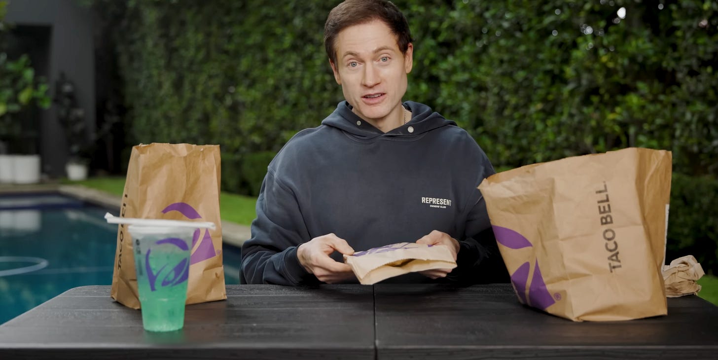 Bryan Johnson sits at a folding table in his backyard surrounded by Taco Bell bags and a Baja Blast Bryan Johnson sits at a folding table in his backyard surrounded by Taco Bell bags and a Baja Blast